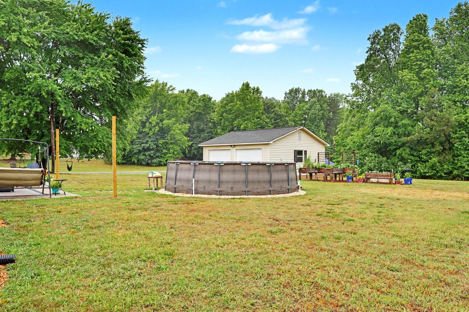 Backyard with above-ground pool and swing set at 1070 Legion Club Road Salisbury NC